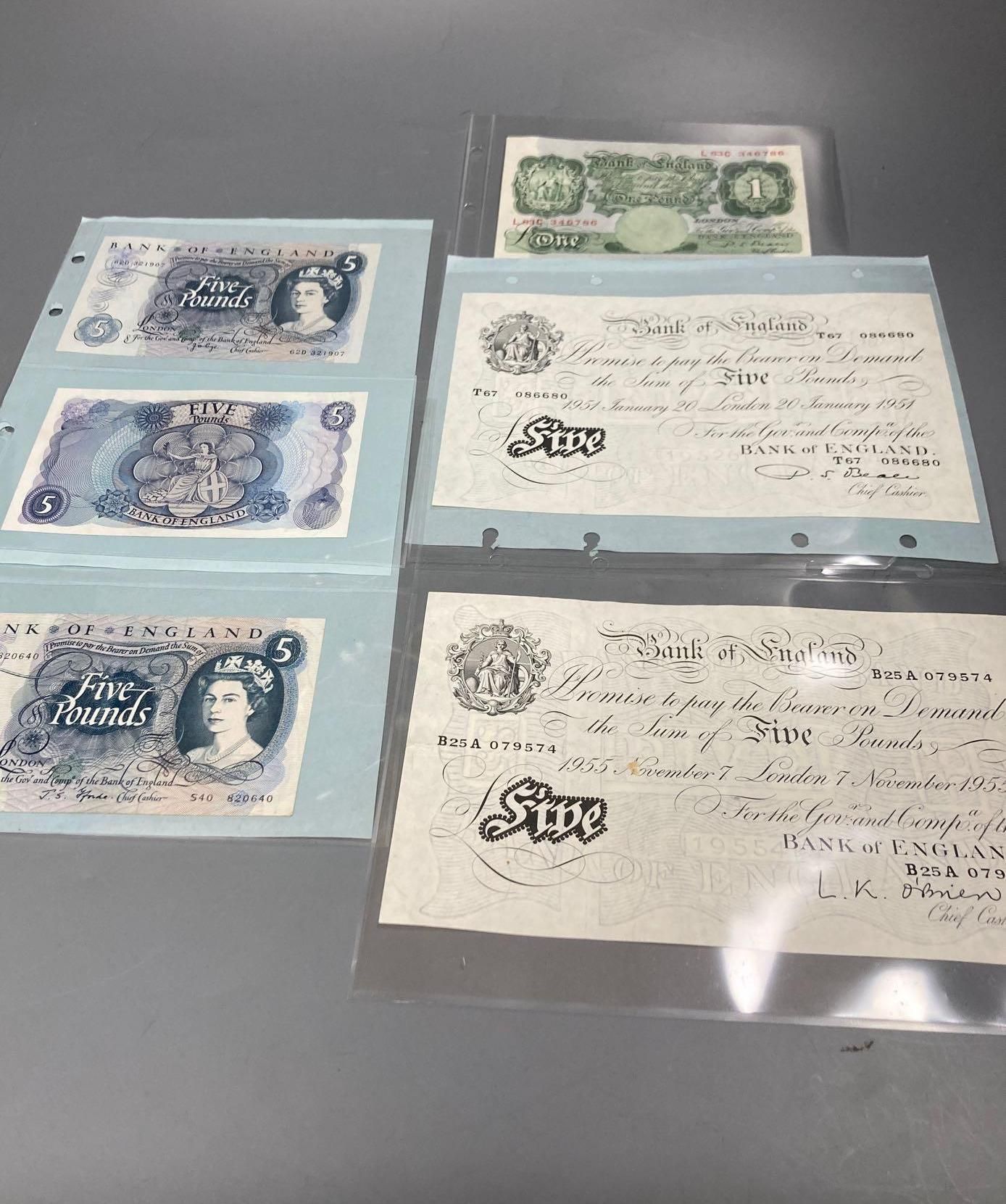 A collection of banknotes, two old £5 notes, three blue £5 notes and one green £1 note